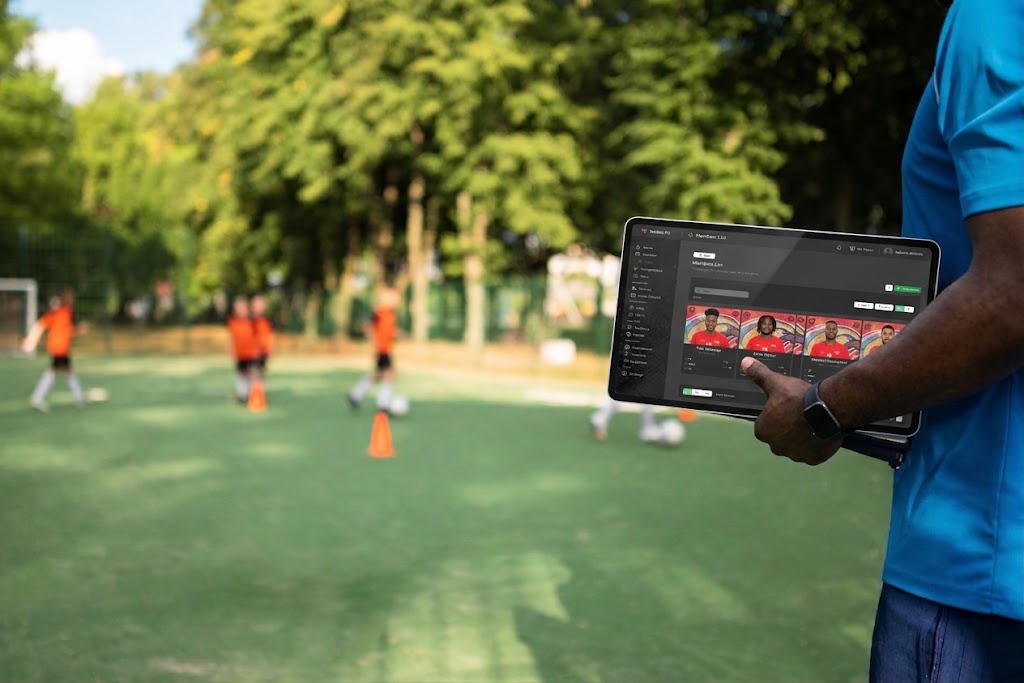 Coach reviewing team stats on a tablet pitchside